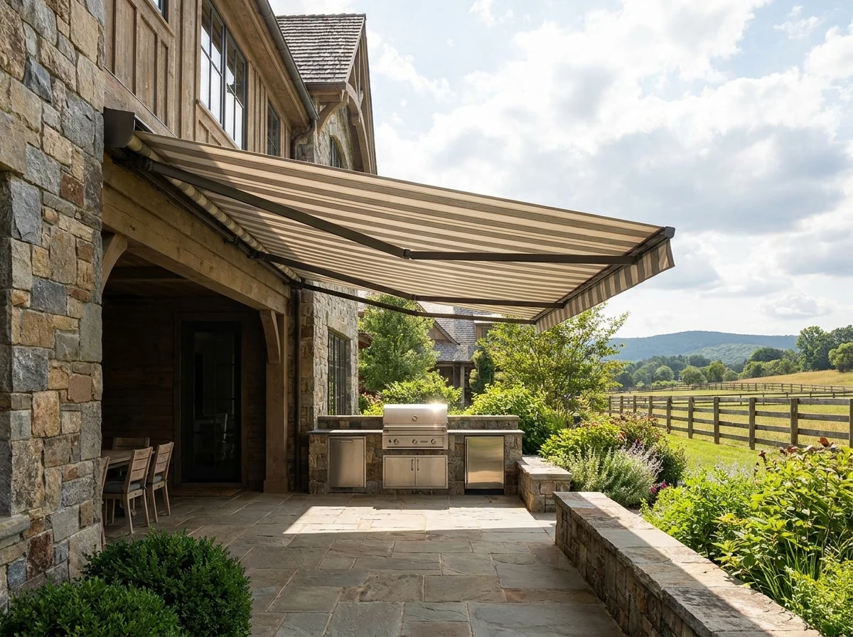 Charcoal folding-arm awning extended over a paved patio at a modern Blue Hills home